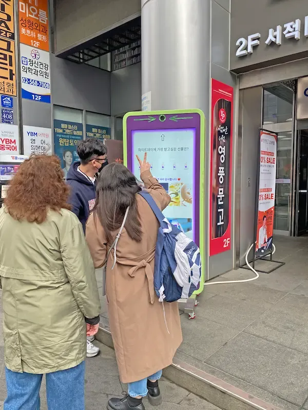 People interacting with FingeRate Bot during event